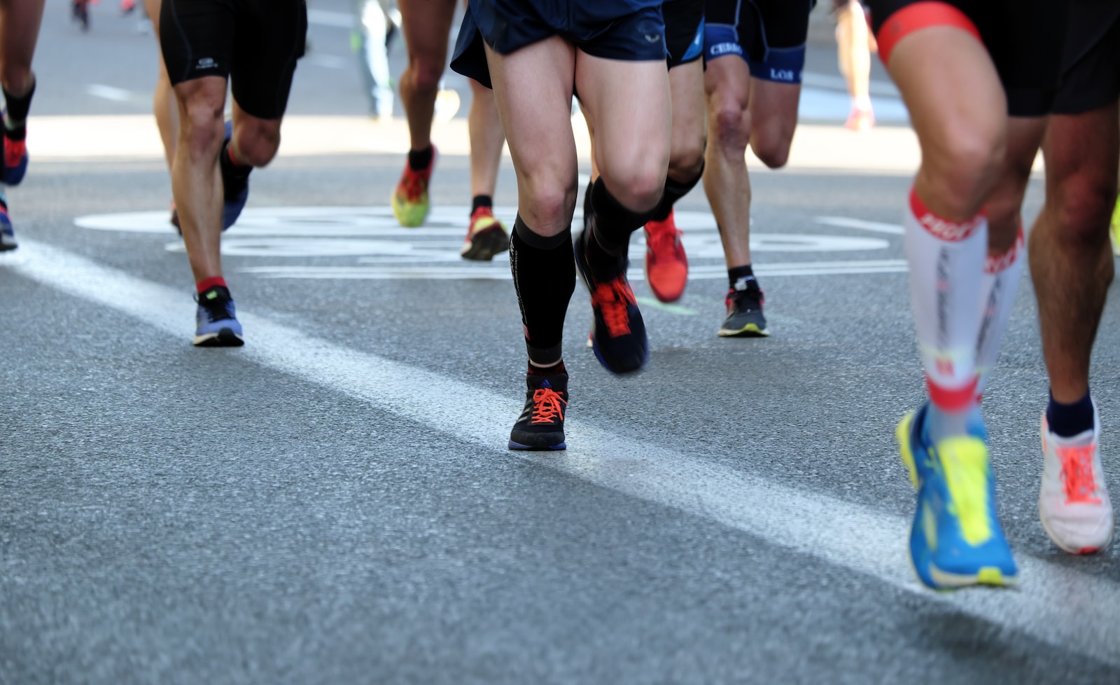 Personnes qui courent sur l'asphalte avec des chaussures de running